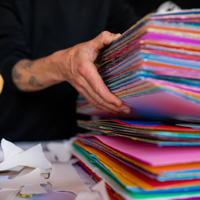 a person holding a stack of colorful folders