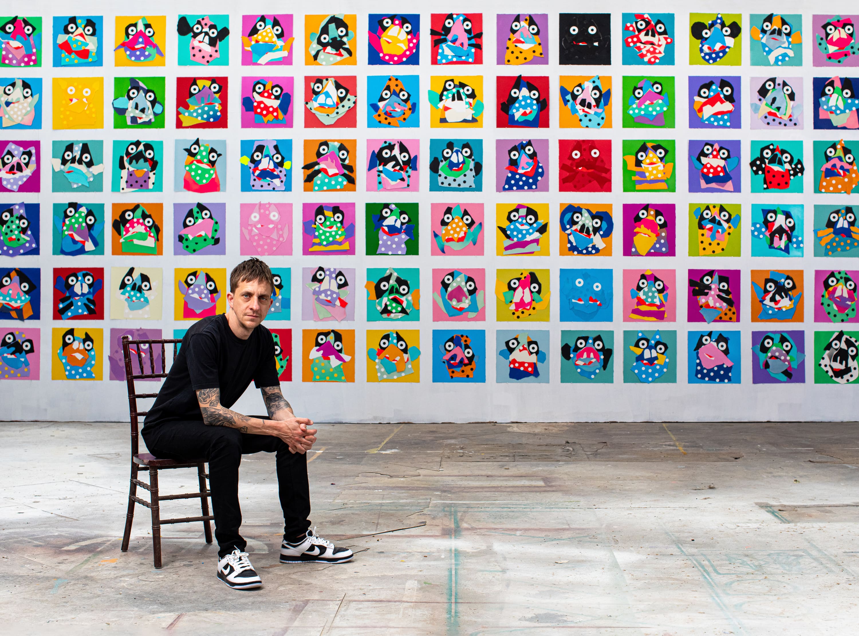 a person sitting in a chair in front of a wall of art